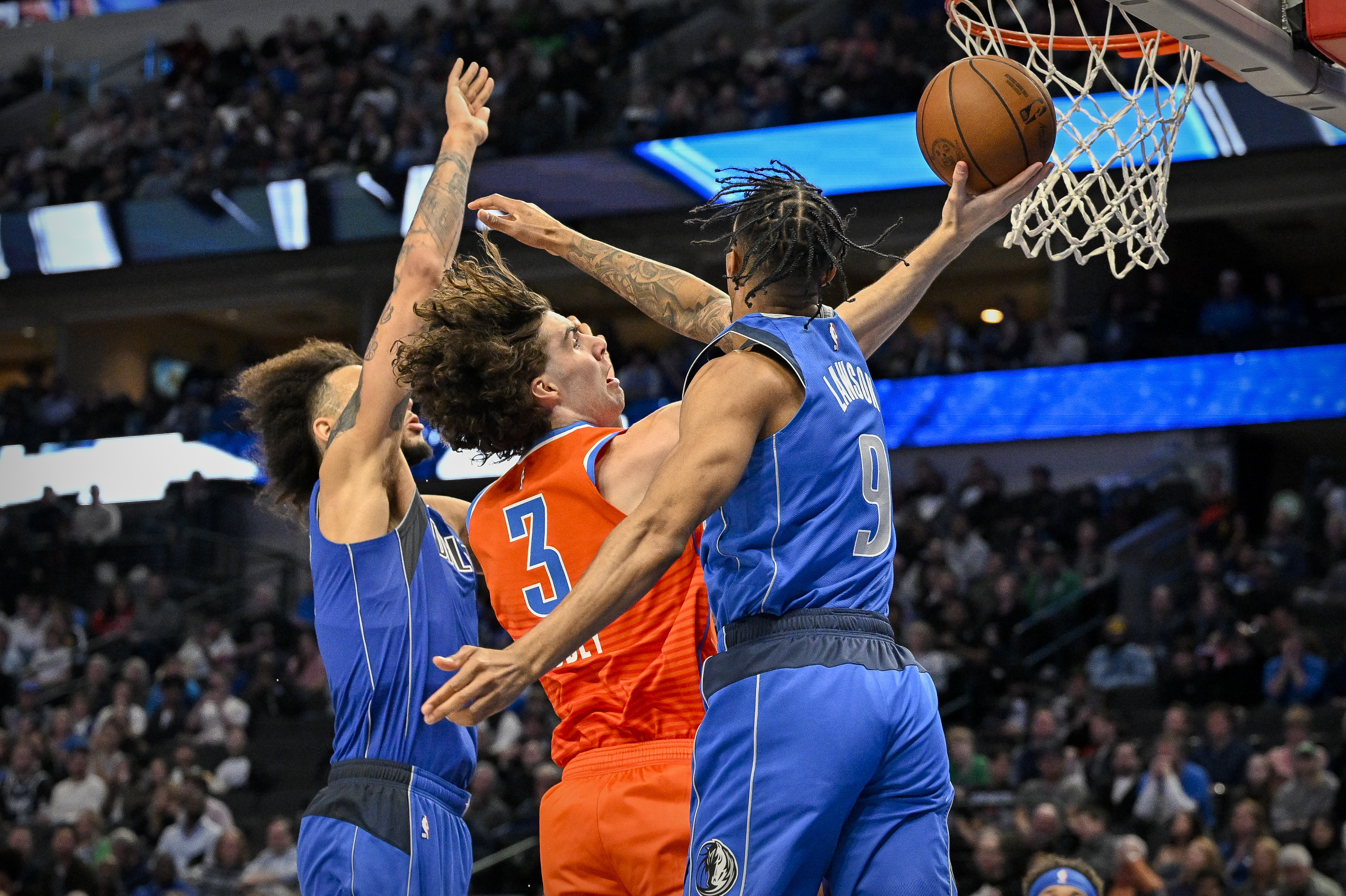 Mavs’ AJ Lawson and Dereck Lively II contend a layup from Thunder’s Josh Giddey.